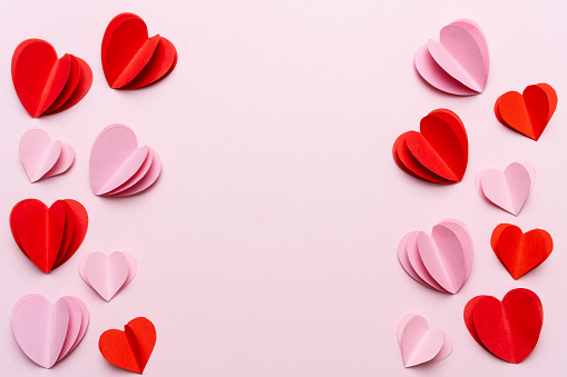 Valentines Day background with red hearts on pink background