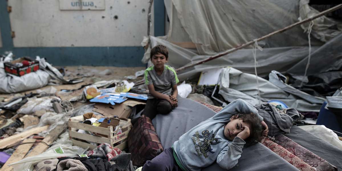 Two boys seen joyless sitting in rubble. 

Image accessed via Getty Images. © Jehad Alshrafi/Anadolu.